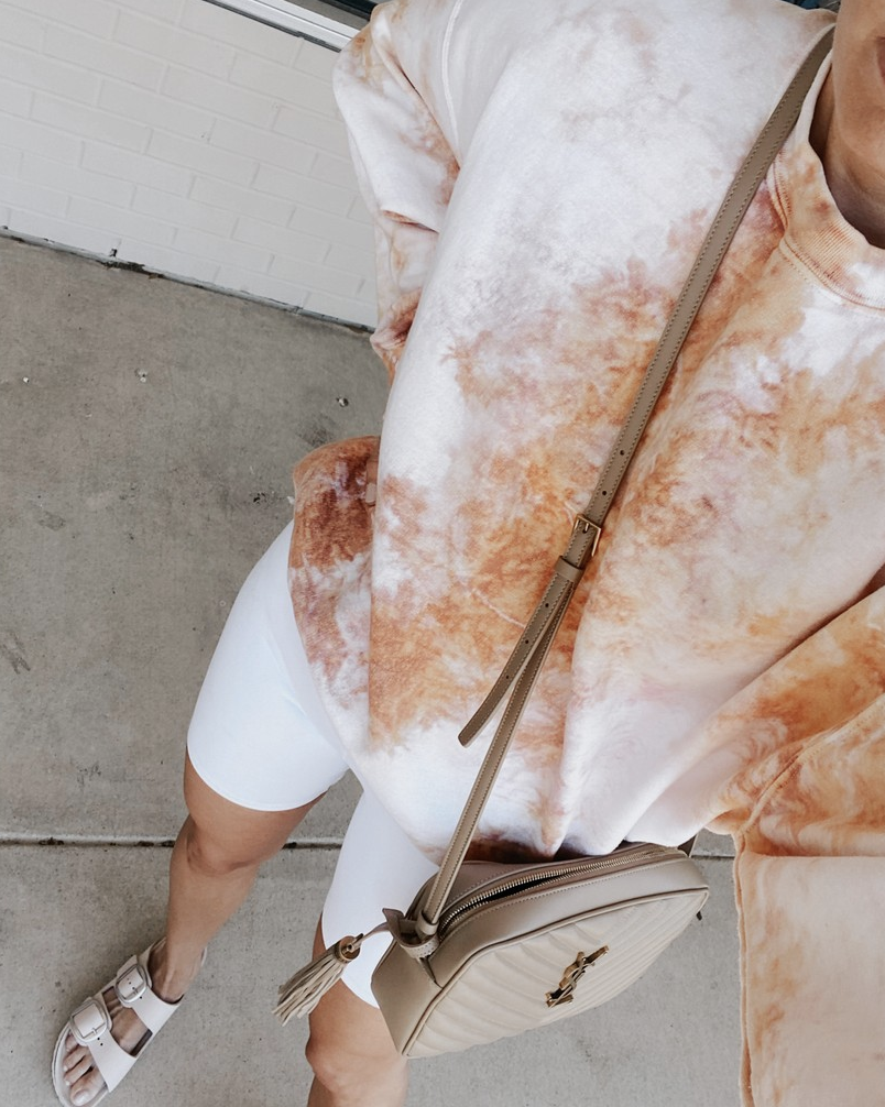 fashion blogger wearing urban outfitters pale pink orange tie dye crew neck sweatshirt with alo white high waist biker shorts