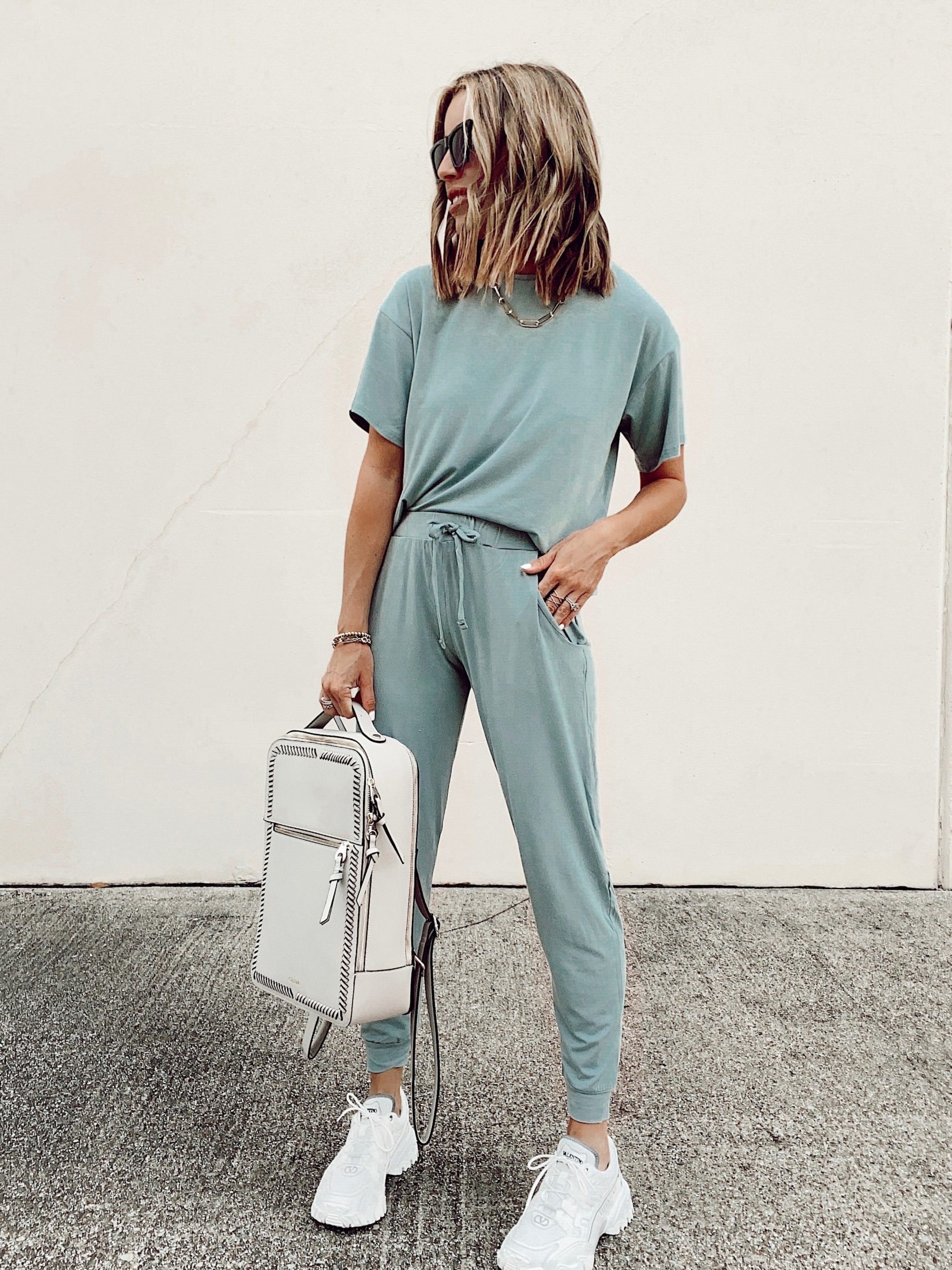 matching loungewear set with valentino white climbers sneakers and calpak kaya stone laptop backpack