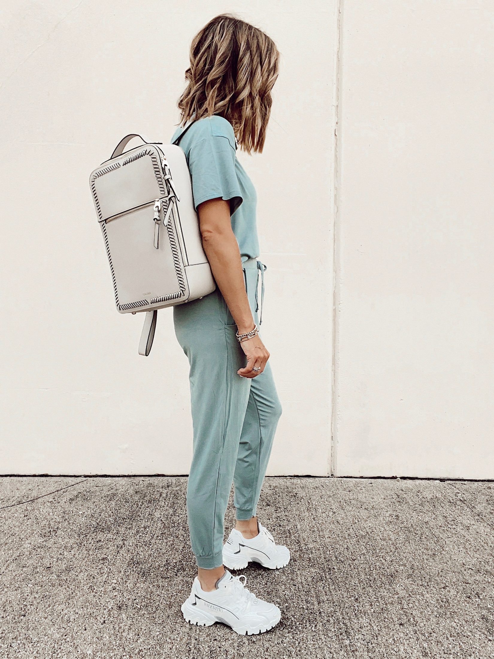 matching loungewear set with valentino white climbers sneakers and calpak kaya stone laptop backpack